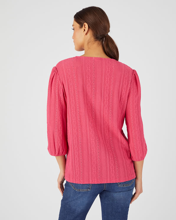Opengewerkte en geborduurde top van stretch jacquardtricot